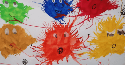 Man sieht verschieden farbige Klecks-Monster auf einem weissen Blatt Papier.