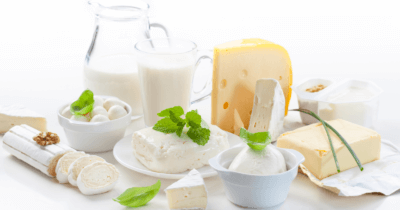 Man sieht Milchprodukte: Käse, Milch, Joguhrt auf einem weissen Hintergrund. Das sind No Foods nach Anthony William.