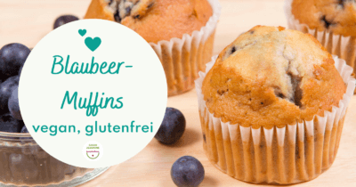 Man sieht das Titelbild vom Blogartikel "Blaubeer-Muffins vegan, glutenfrei. Es sind Muffins und Blaubeeren zu sehen. Dies ist der Montasrückblick vom März 2022 von Jeannine Gashi, Lymphbalance.